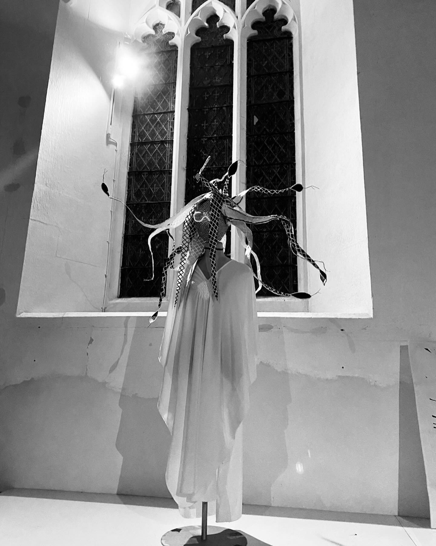 Medusa head-dress with draped garment installed in a church window alcove.